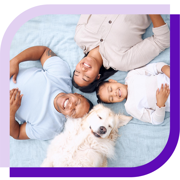 image of a happy family lying on a bed with their dog